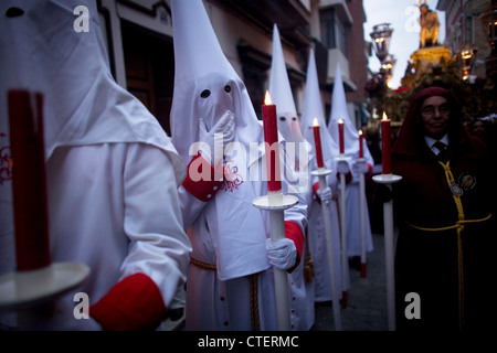 Büßer halten Kerzen während der Prozession des Vaterunsers Jesu Demut und Geduld während der Karwoche in Spanien Stockfoto