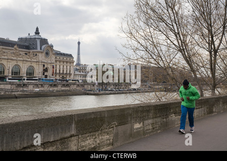 Mann Joggen entlang der Seine, gegenüber ist der Eiffelturm und Musée d ' Orsay, Paris, Frankreich Stockfoto