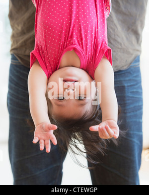 USA, New Jersey, Jersey City, Vater hält baby Tochter (12-17 Monate) auf den Kopf gestellt Stockfoto