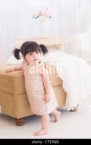 USA, New Jersey, Jersey City, Porträt von Babymädchen (12-17 Monate) stehen in der Nähe von sofa Stockfoto
