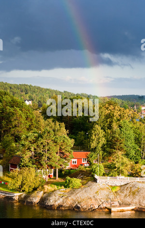 Regenbogen unter kleinen Dorf am Baltischen Meer Stockfoto