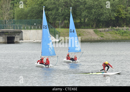 Windsurfer und Segelboote am unteren Behälter Gorton, Debdale Park, Manchester Stockfoto