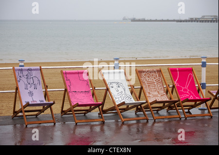 Die Weymouth Esplanade ist mit 500 Liegestühlen und Liegestühlen ausgestattet, die von den Einheimischen am Weymouth Beach, Dorset UK, an einem regnerischen Tag im Juli entworfen wurden Stockfoto