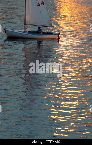 Kleines Segelboot auf dem Charles River bei Sonnenuntergang in Boston Stockfoto