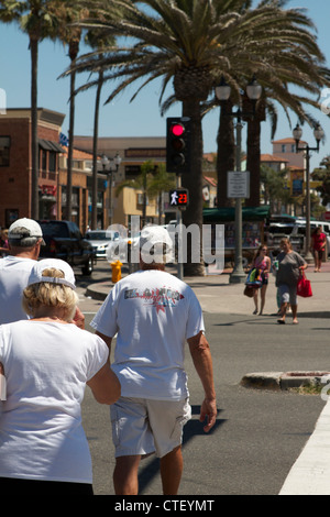 Menschen, die den Kreuzweg am Pacific Coast Highway am Pier in Huntington Beach Kalifornien Stockfoto
