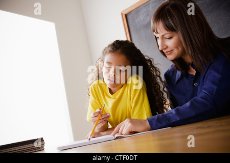 USA, California, Los Angeles, Schülerin mit Lehrer im Klassenzimmer schreiben Stockfoto