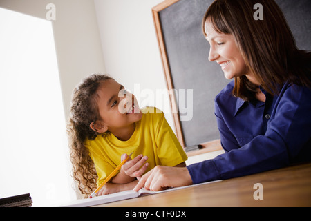 USA, California, Los Angeles, Schülerin mit Lehrer im Klassenzimmer schreiben Stockfoto