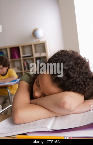 USA, California, Los Angeles, Mädchen (10-11) Nickerchen auf Schreibtisch mit jungen (10-11) im Hintergrund Stockfoto