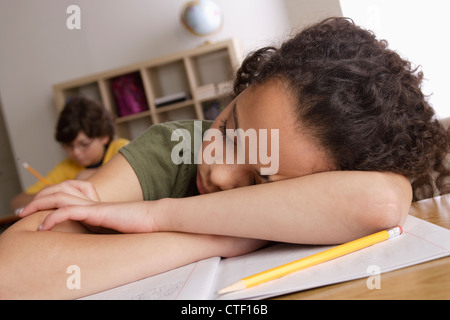 USA, California, Los Angeles, Mädchen (10-11) Nickerchen auf Schreibtisch mit jungen (10-11) im Hintergrund Stockfoto