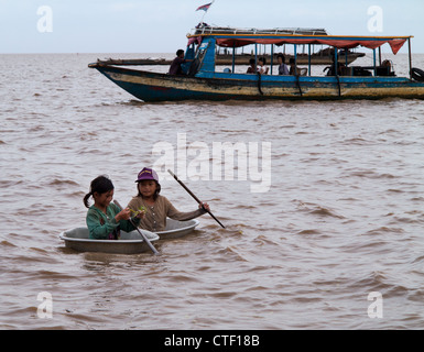 TONLE SAP, Kambodscha - 30 Juni: Zwei Mädchen in runden Booten Ansatz touristischen Boot auf See Tonle Sap, Kambodscha am 30. Juni 2012. Stockfoto