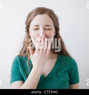 Studioaufnahme der glückliche junge Frau Gähnen Stockfoto