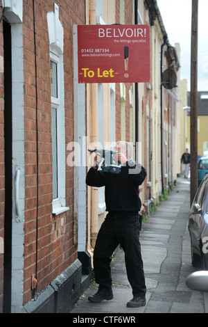 Ein Arbeiter von einer Vermietungsagentur behebt ein Zeichen "Zu lassen", um eine Immobilie in Gloucester UK Stockfoto