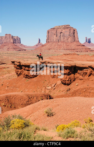 Ein Indianer auf einem Pferd vor einem roten Felsformationen in Monument Valley Stockfoto