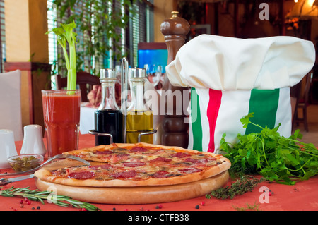 Nahaufnahme einer Tabelle mit Pizza und Koch Hut Stockfoto