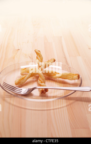 Blätterteig-sticks auf einer transparenten Glasplatte über Kiefer Holz Tisch Stockfoto