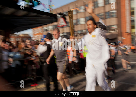 Olympische Flamme und Fackel Träger laufen in Dalston, Hackney, während London 2012 Fackellauf Stockfoto