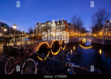 Amsterdam, Dämmerung, Überquerung der Kanäle genannt Keizersgracht En Leidsegracht. Beleuchteten Brücken, Fahrräder. UNESCO-Weltkulturerbe. Stockfoto