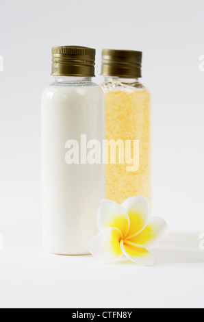 zwei Flaschen und frischen Frangipani auf weißem Hintergrund Stockfoto