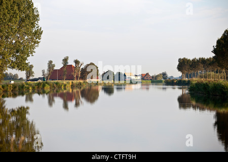 Die Niederlande, Zuid Beemster Beemster Polder, Farm hinter Deich des Kanals, das Wasser zum Meer transportiert. Stockfoto