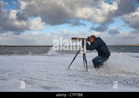 Die Niederlande, IJmuiden, Fotograf Frans Lemmens am Pier bei Sturm. Stockfoto