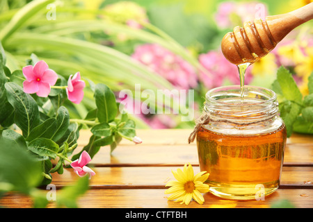 Honig im Glas Gläser mit Blumen Hintergrund. Stockfoto