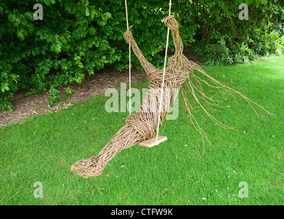 Wicker Mädchen sitzen auf Gartenschaukel Stockfoto