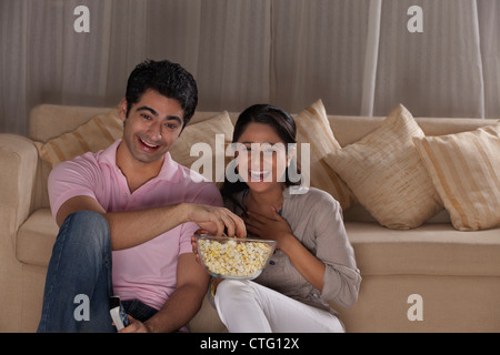 Glückliches junges Paar vor dem Fernseher zu Hause genießen Stockfoto