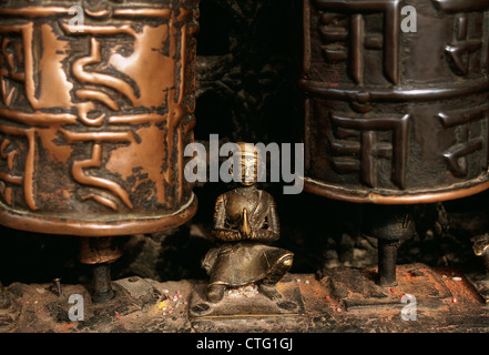 Skulptur eines ergebenen zwischen zwei Gebetsmühlen in einem buddhistischen Tempel (Nepal) Stockfoto
