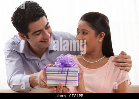 Hübscher junger Mann, die Frau zu Hause ein Geschenk geben Stockfoto
