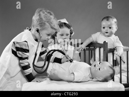 1950ER JAHREN JUNGEN UND MÄDCHEN SPIELEN ARZT UND KRANKENSCHWESTER MIT STETHOSKOP UND PUPPEN Stockfoto