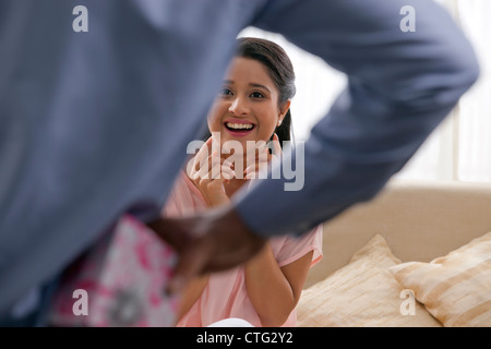 Man versteckt sich hinter seinem Rücken von Frau Geschenk Stockfoto