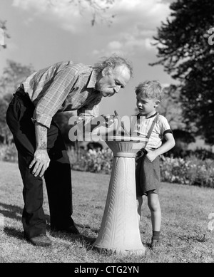 1940ER JAHRE ÄLTEREN MANN ZEIGEN JUNGE SONNENUHR FUNKTIONSWEISE Stockfoto