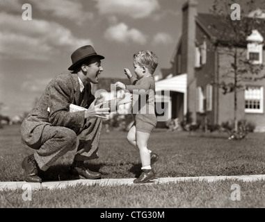 1940ER JAHREN VATER GRUß SOHN LAUFEN IN RICHTUNG IHN AUF BÜRGERSTEIG Stockfoto