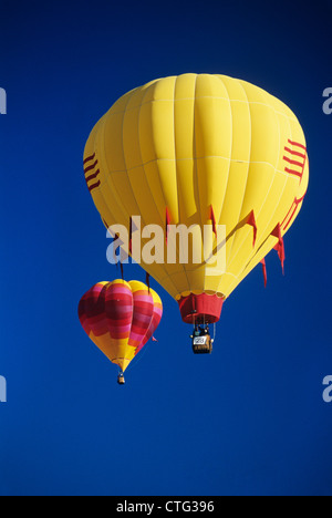 1990ER JAHREN ROT UND GELB HEIßLUFT BALLONS IN BLAUEN WOLKENLOSEN HIMMEL Stockfoto