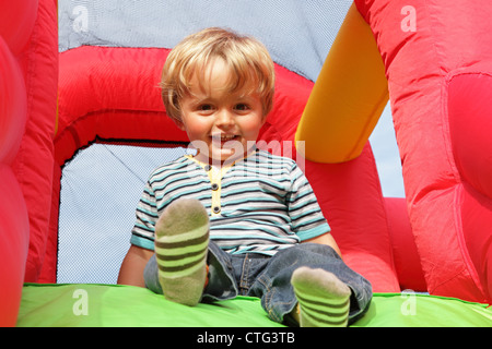 Kind auf aufblasbare Hüpfburg Stockfoto