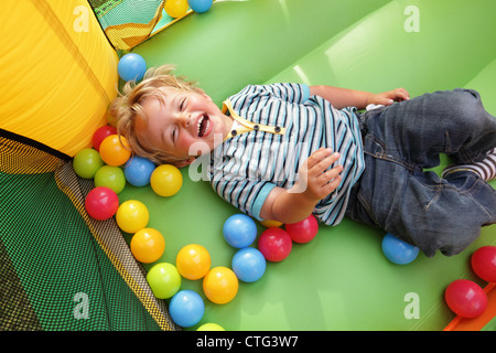 Kind auf aufblasbare Hüpfburg Stockfoto