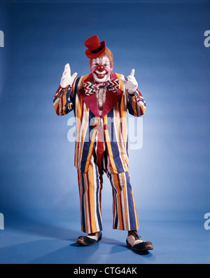 1970ER JAHREN VOLLER LÄNGE PORTRAIT VON CLOWN IN GESTREIFTEN KOSTÜM Stockfoto