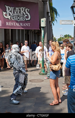 Straßenkünstler Silber lackiert unterhält Touristen auf dem Bürgersteig im French Quarter von New Orleans, LA Stockfoto