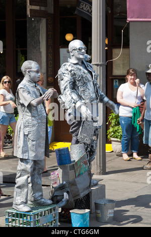 Erwachsener und Kind Silber lackiert Straßenkünstler unterhalten Touristen auf dem Bürgersteig im French Quarter von New Orleans, LA Stockfoto