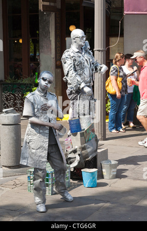 Erwachsener und Kind Silber lackiert Straßenkünstler unterhalten Touristen auf dem Bürgersteig im French Quarter von New Orleans, LA Stockfoto
