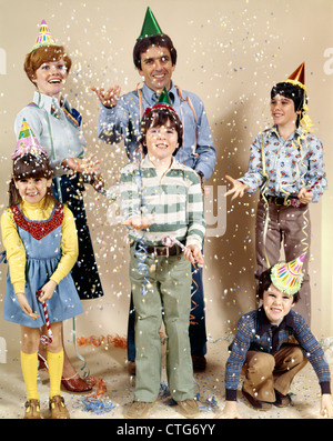 1970ER JAHRE FAMILIE MIT 4 KINDERN WERFEN PARTY KONFETTI Stockfoto