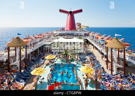 Kreuzfahrt-Passagiere genießen Sie die Sonne auf dem Deck des Kreuzfahrtschiffes Carnival Fascination Stockfoto