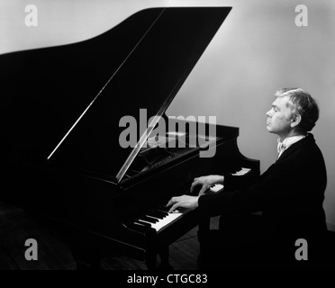 ÄLTERER MANN MIT ERGRAUTEN HAAREN SMOKING SPIELEN GRAND PIANO Stockfoto