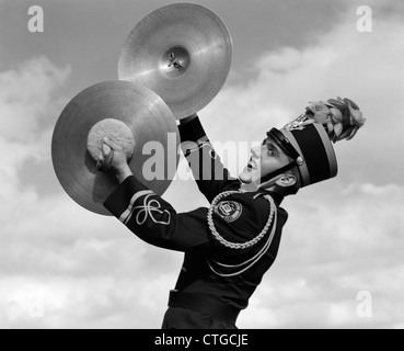 1960ER JAHRE PORTRAIT EINES JUNGEN IN BAND EINHEITLICHE SPIELEN INSTRUMENT BECKEN IM FREIEN Stockfoto