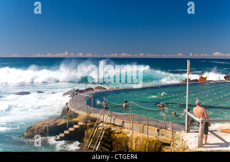 Bronte Bäder Oceanside Schwimmbad mit Schwimmer racing und Wellenrauschen im Hintergrund Bronte Sydney NSW Australia Stockfoto