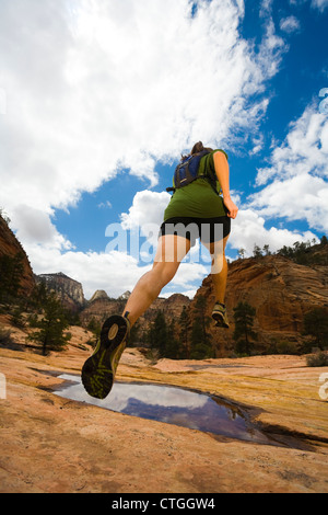 Persische Frau über Canyon Pfütze springen Stockfoto