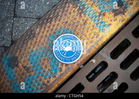 Warnschild am Gully in Hoboken, New Jersey in Bezug auf Abwasser Behandlung zu umgehen und fließen direkt in die Wasserstraße. Stockfoto