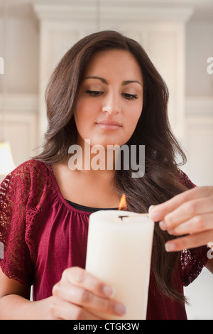Gemischte Rassen Frau Beleuchtung Kerze Stockfoto