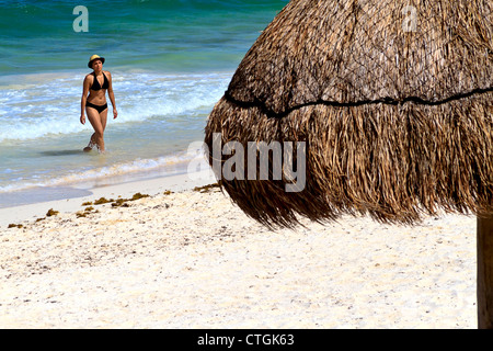 Frau verlässt Surf an einem Strand entlang der Riviera Maya, Yucatan, Mexiko Stockfoto