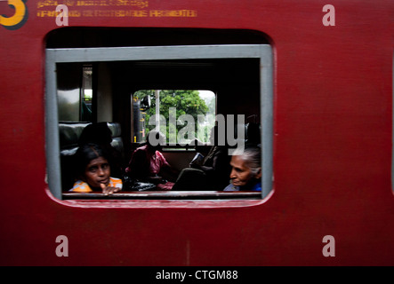 Mädchen und alte Dame schauen aus dem Fenster des Zuges in Sri Lanka. Stockfoto